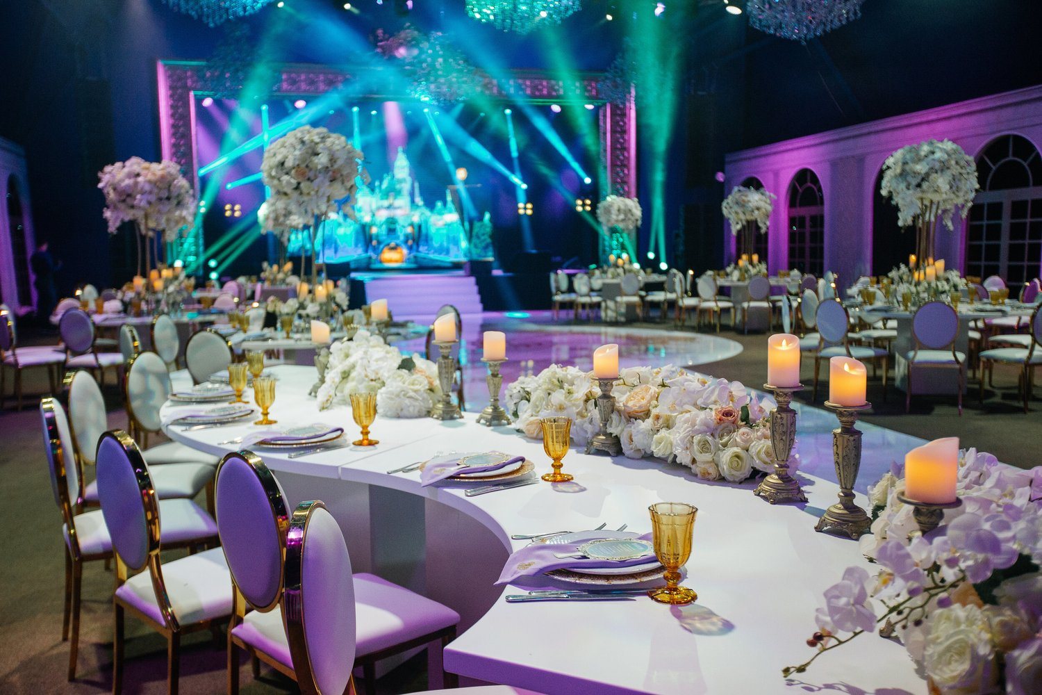 A reception room with a stage and event lighting
